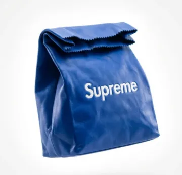 BRAND NAME]. A high-end conceptual leather clutch designed in the exact shape and silhouette of a classic disposable paper lunch sack (rolled top, rectangular base, NO HANDLES). The object is floating weightlessly in the center.

**CRITICAL SHAPE & FORM:**
The object must mimic a folded paper lunch bag. It has jagged/crimped cut edges at the top opening. The top is rolled or folded over casually. It must NOT have any handles or straps.

**CREATIVE COLOR PALETTE & BRANDING:**
The AI must act as a color stylist. Do not default to standard brand colors. Generate a unique, bold, fashion-forward color combination.
* **Bag Color:** A vivid, unexpected luxury tone (e.g., Electric Lime, Deep Ultraviolet, Burnt Orange, or Cobalt Blue).
* **Logo Size & Color:** A **medium-sized, centrally placed** `[BRAND NAME]` logo is deeply embossed on the front. Do NOT make the logo huge or oversized; keep it proportional and elegant with plenty of negative space around it. The logo is stamped with a highly contrasting color (e.g., White logo on Blue bag) to make it readable.

**MATERIALS:**
Ultra-premium, soft-grain calfskin leather that mimics the crinkles and folds of paper. Hyper-realistic leather texture.

**ENVIRONMENT & BACKGROUND:**
A seamless, perfectly clean, pure white studio cyclorama background. High-key brightly lit environment.

**LIGHTING & ATMOSPHERE:**
High-key editorial lighting. A strong backlighting setup creates a glowing "light aura" (halation) around the edges of the bag against the white background. The edges are slightly blown out.

**CAMERA:**
Medium format, 100mm lens, f/5.6. Slight shallow depth of field (sharp logo, soft back).